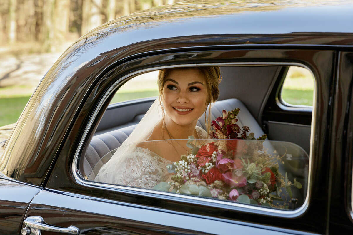 Trauzeugin blickt auf die Braut im Auto n